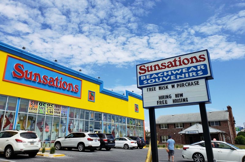 Sunsations, a chain that sells beach gear and clothing, has signs up at most of its Ocean City, Maryland, locations offering free housing for workers. (WTOP/Colleen Kelleher)